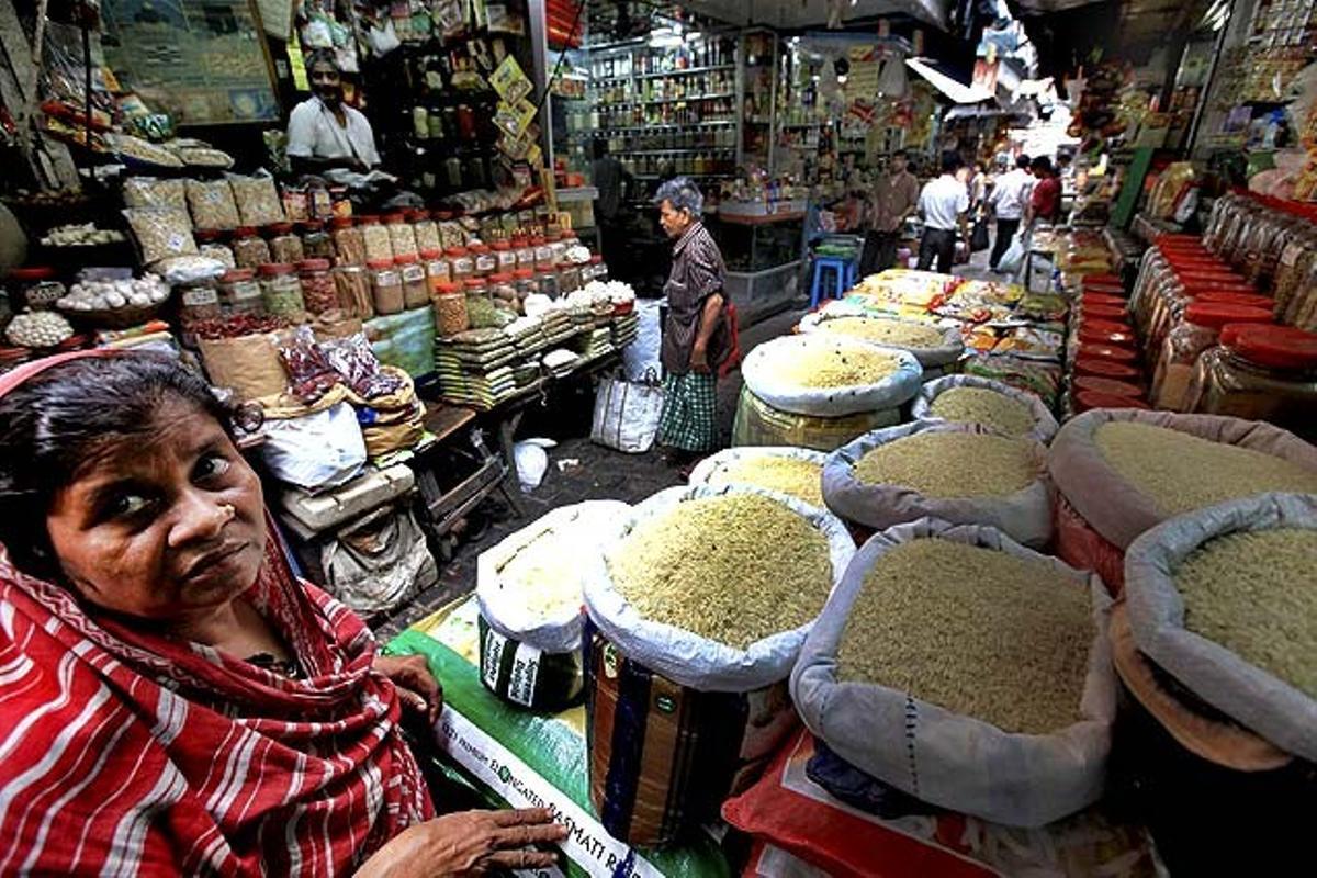 Una dona espera davant una parada d’un mercat de la ciutat de Calcuta, a l’est de l’Índia.