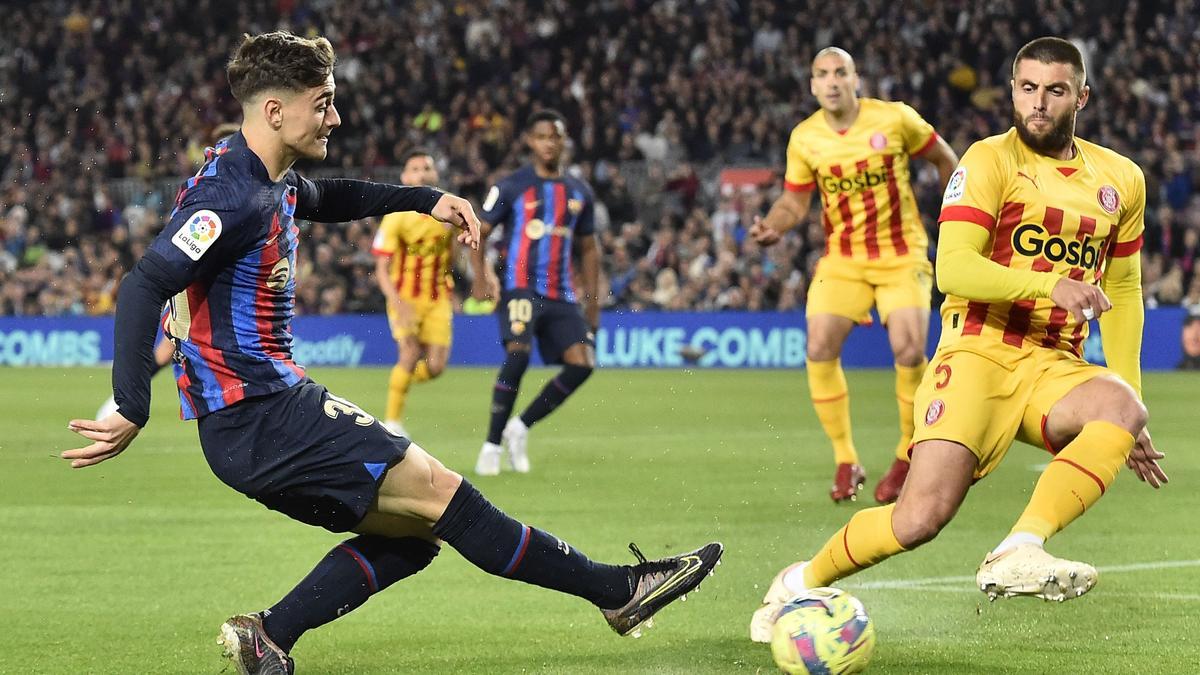 Barcelona's Spanish midfielder Gavi (L) is challenged by Girona's Spanish midfielder David Lopez during the Spanish league football match between FC Barcelona and Girona FC at the Camp Nou stadium in Barcelona on April 10, 2023. (Photo by Pau BARRENA / AFP)