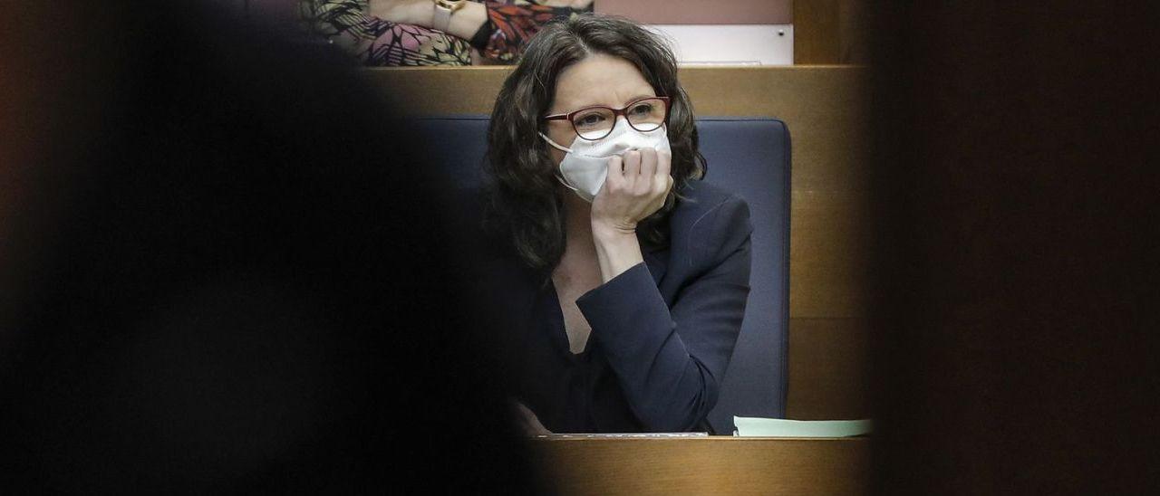 La vicepresidenta del Consell, Mónica Oltra, con mascarilla, sentada en su escaño de la bancada azul de las Corts.