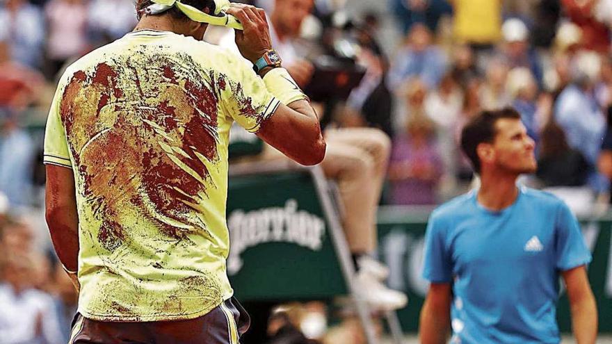 Nadal, con la espalda llena de arcilla, se retira la cinta del pelo