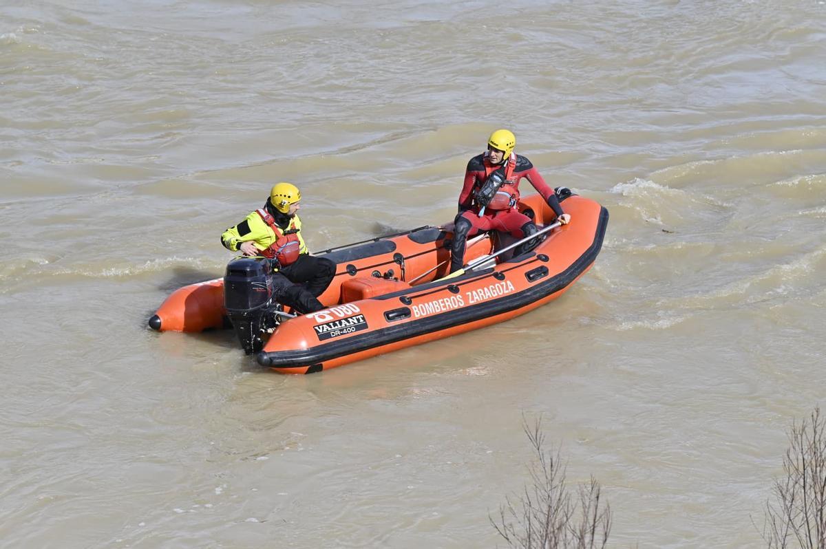 Bomberos del Ayuntamiento de Zaragoza, este domingo, en el río Ebro a su paso por Zaragoza.