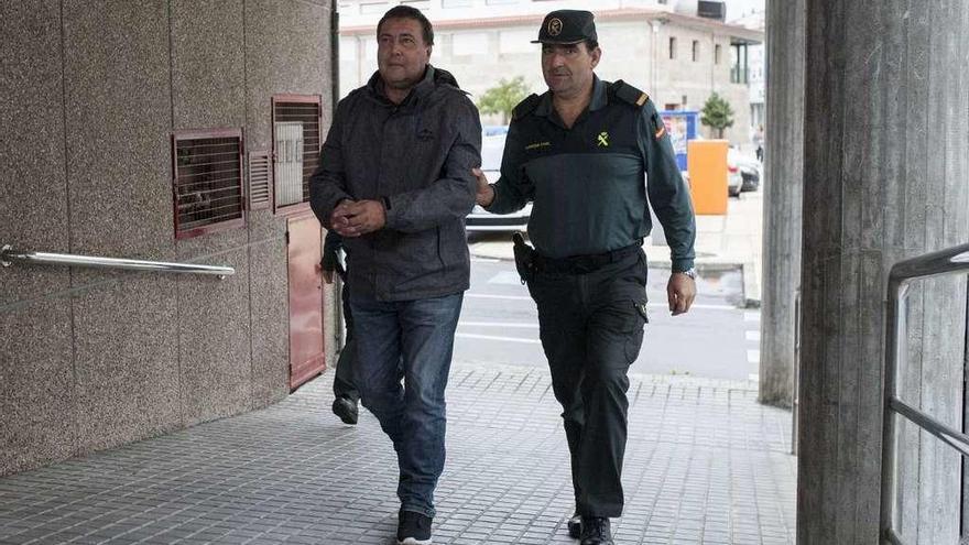 El detenido, a su llegada al juzgado, esposado y custodiado por la Guardia Civil. // Brais Lorenzo