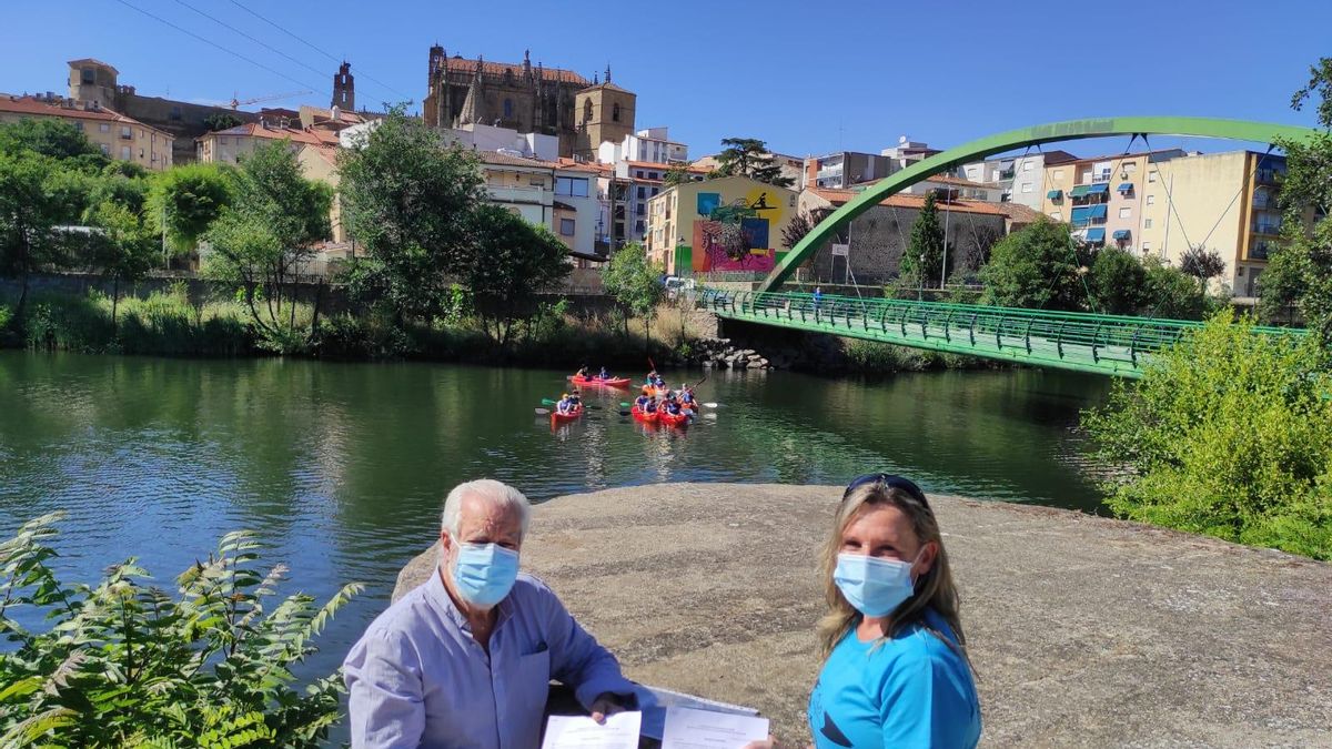 Paco Valverde y Lidia Regidor, con el convenio y los piragüistas al fondo.