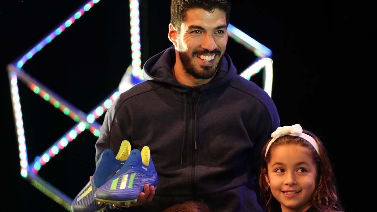Luis Suárez recibe de manos de sus hijos las botas de Adidas que usará en el Mundial de Rusia.