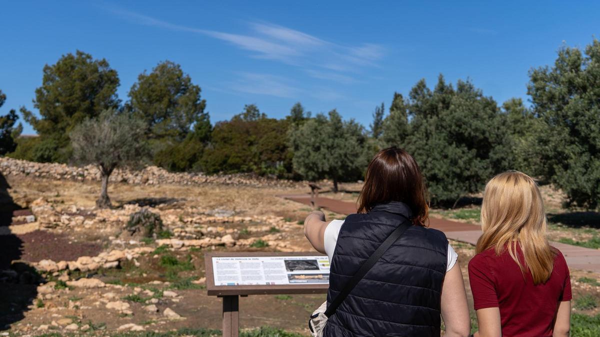 Turistas visitando uno de las paradas sobre patrimonio histórico de Riba-roja de Túria.