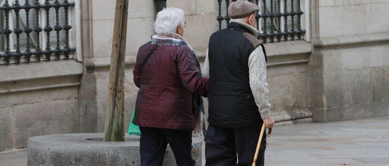 Una pareja de personas mayores pasea por Ourense.