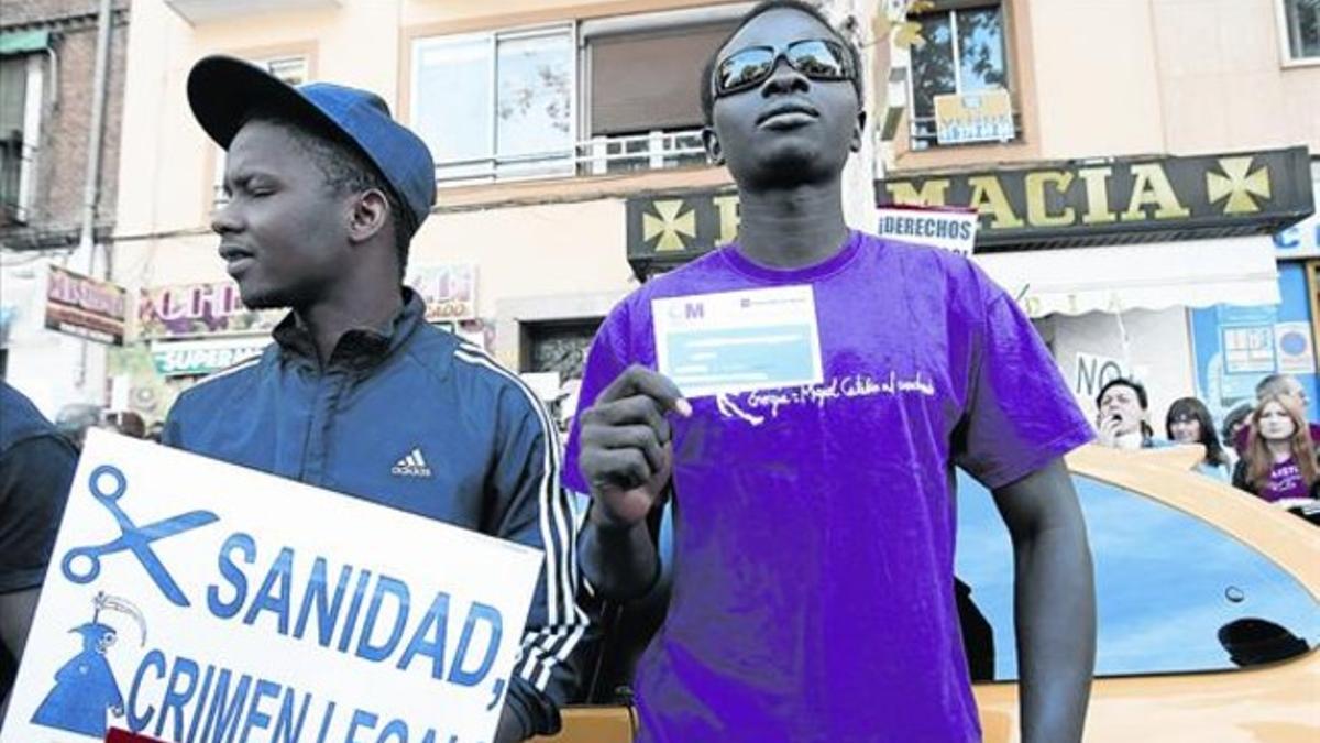 Dos inmigrantes se manifiestan contra el cobro de la tarjeta sanitaria ante el hospital Gregorio Marañón de Madrid, en septiembre del 2012.