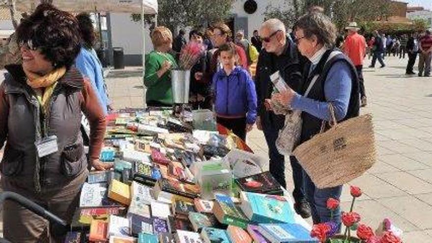 Un grupo de lectores se interesa por los libros en la parada de la biblioteca insular.