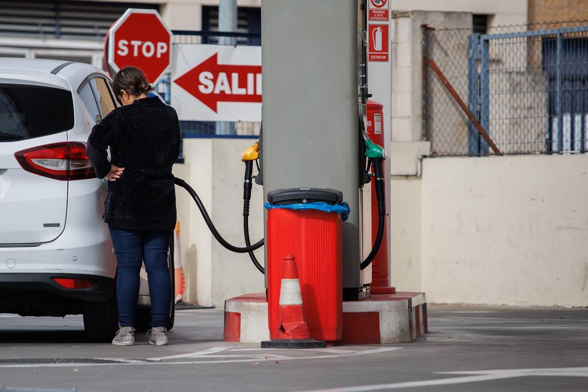 Una mujer reposta en una gasolinera.