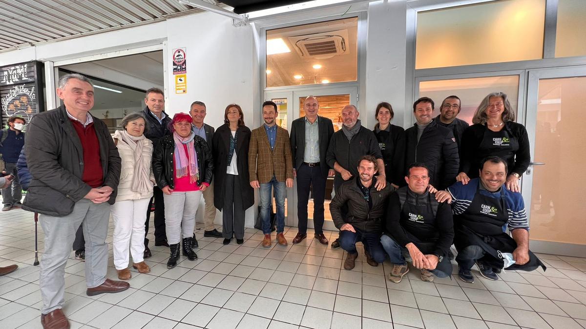 Los representantes de las instituciones y los de la cooperativa, en la puerta del Mercat Nou.