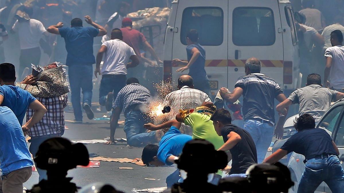 Fieles palestinos corren a resguardarse del gas lacrimógeno lanzado por las fuerzas de seguridad israelís en la Ciudad Vieja de Jerusalén, en una imagen de archivo, el 21 de julio.