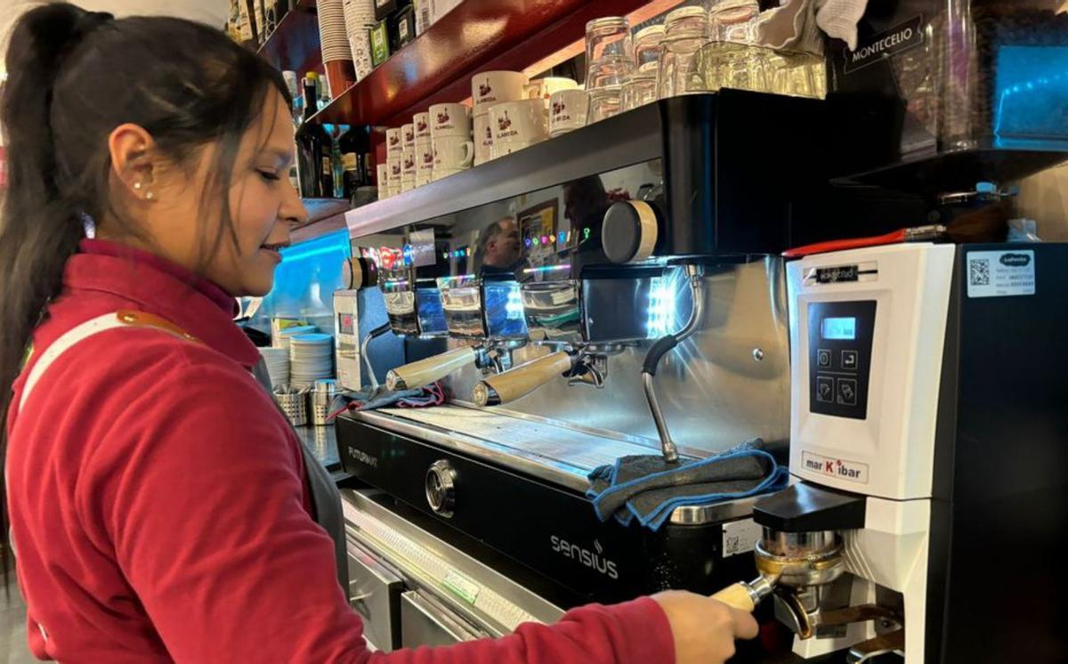 Arriba, la venezolana Kelly Valbuena, en una cafetería de Vegadeo.  Debajo, Claudia Cáceres, de Paraguay, en la caja de un supermercado.  |
