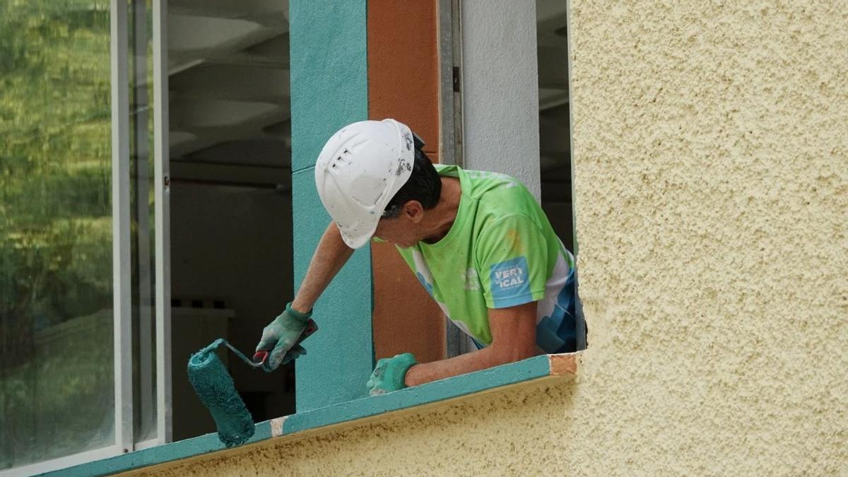 Un operario acomete la mejora de una ventana en un centro de Santa Cruz.