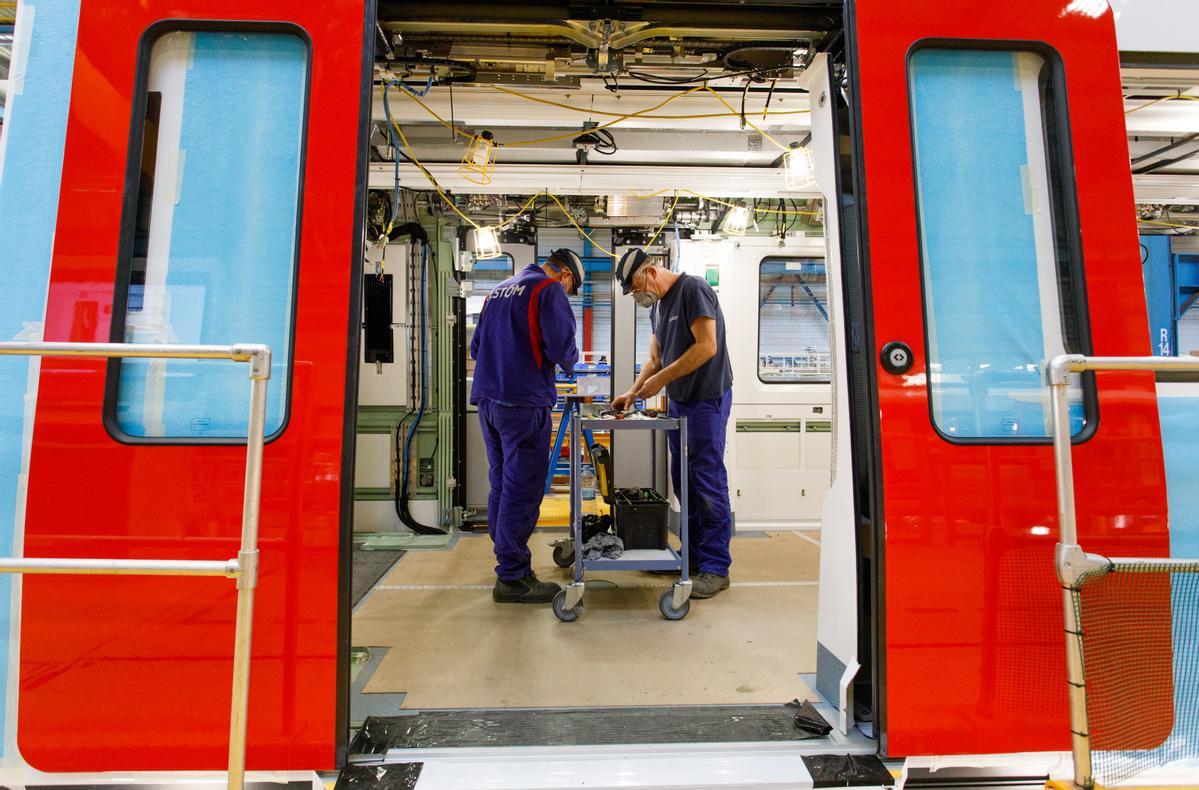 Dos operarios de Alstom montan uno de los nuevos trenes de la L1 y la L3 del metro de Barcelona.