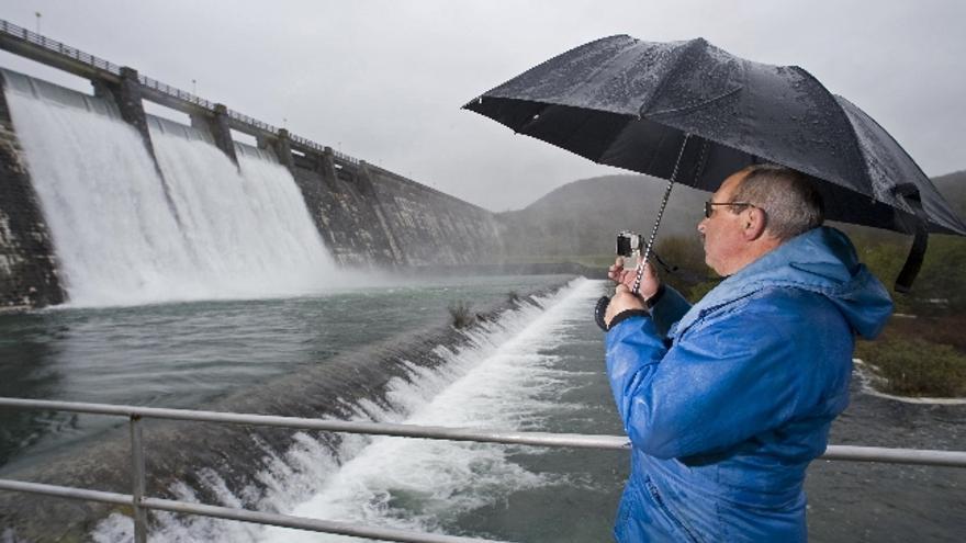 Un hombre graba con su videocámara cómo cae el agua del pantano de Ullibarri Gamboa tras que hayan abierto tres de las siete compuertas de la presa de las cercanías de Vitoria que abastece a la capital alavesa y al gran Bilbao.