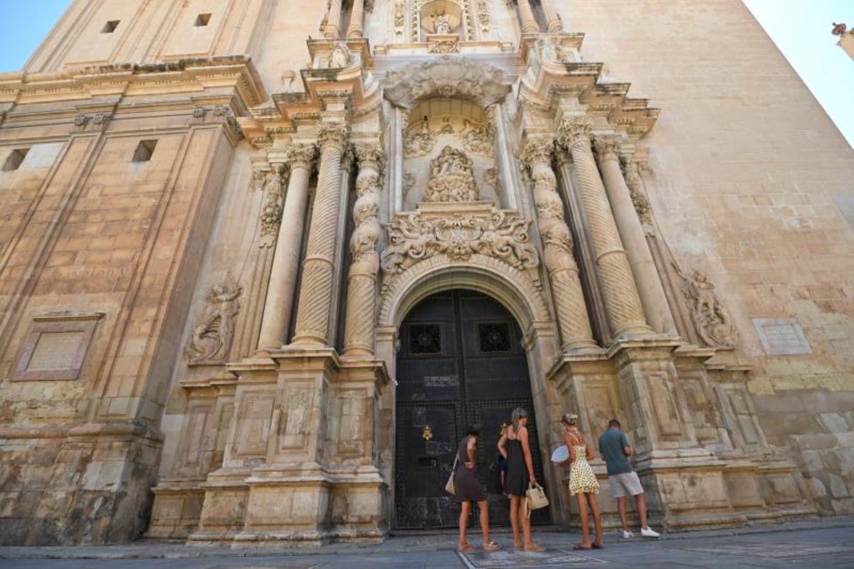 Turistas junto a la Puerta Mayor de la basílica de Santa María.