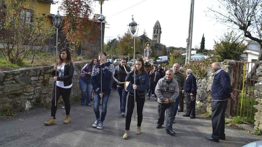 Procesión con la imagen de san Martino por las calle de Mombuey, con la torre templaria al fondo.