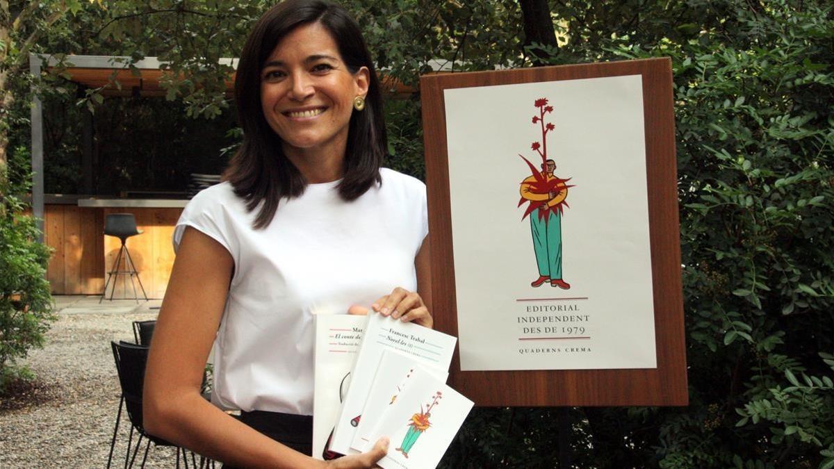 Sandra Ollo, editora de Quaderns Crema, junto al cartel que ilustra la nueva etapa de la editorial.