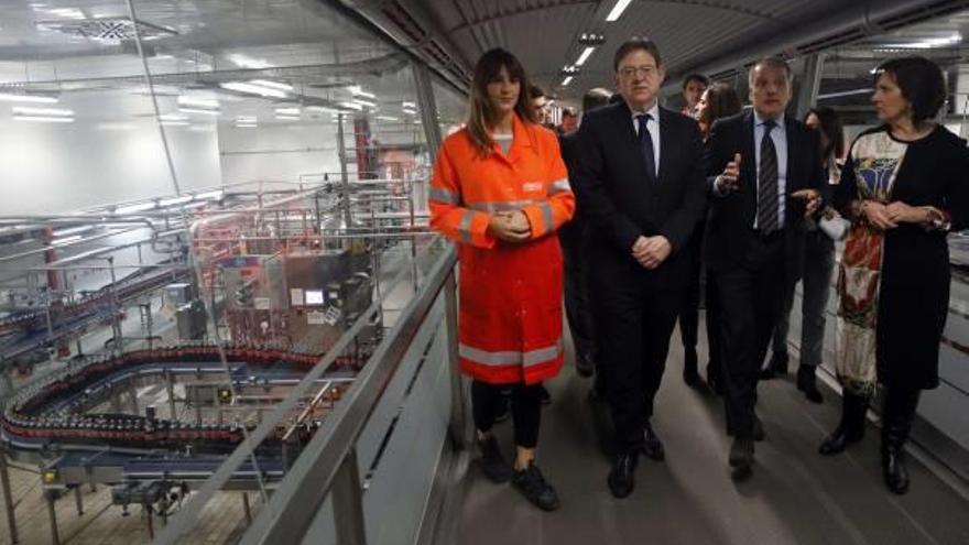Puig, acompañado por directivos de Coca-Cola y la alcaldesa de Quart, ayer, en la fábrica.