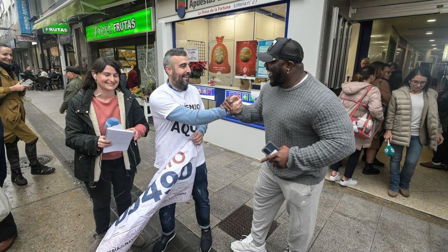 Un empleado de la administración de La Coruña sita en unas conocidas galerías comerciales celebra con un cliente haber vendido décimos del Gordo. | Europa Press