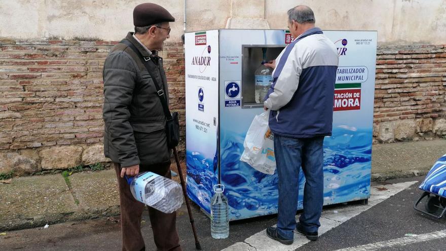 Dos vecinos de Toro sacan agua de una potabilizadora portátil. | M. J. C.