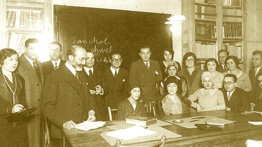 Menéndez Pidal, con barba, rodeado de filólogos, entre ellos, Lapesa y Pilar Lago, sentada, en el centro.