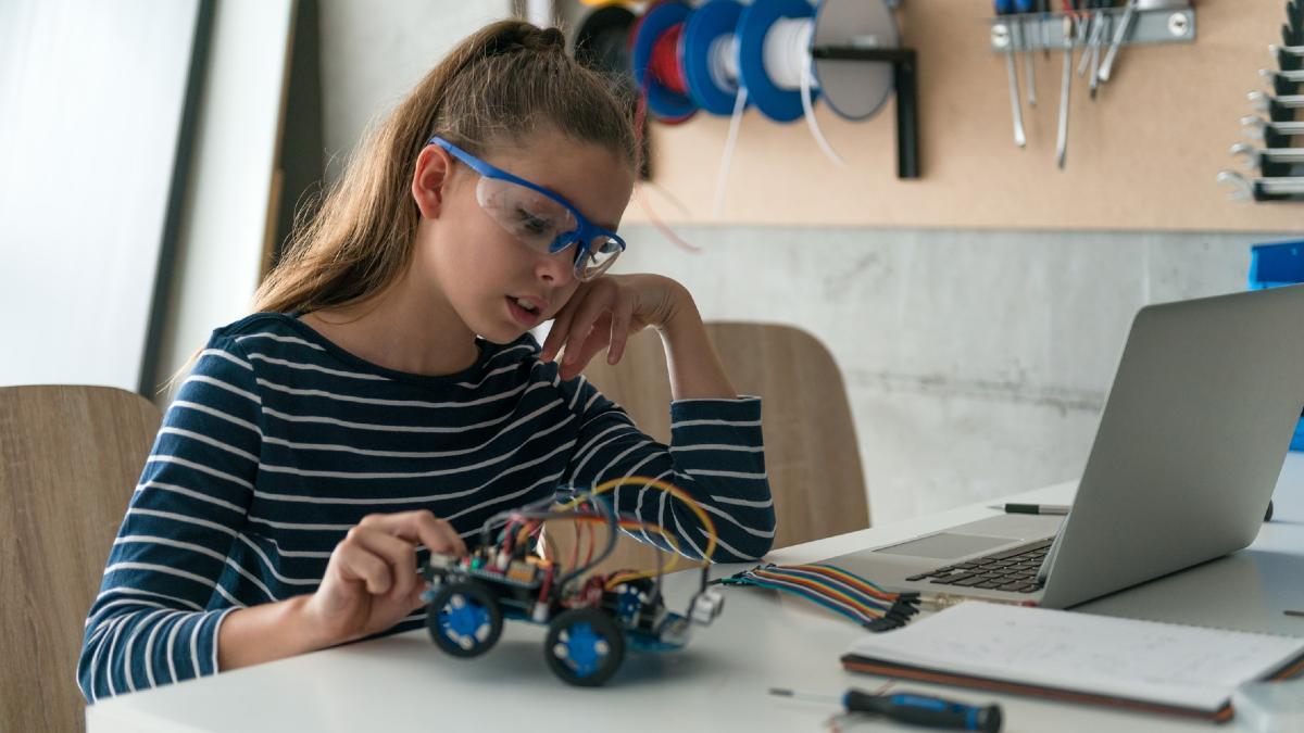 Una niña trabaja en un proyecto de robótica.