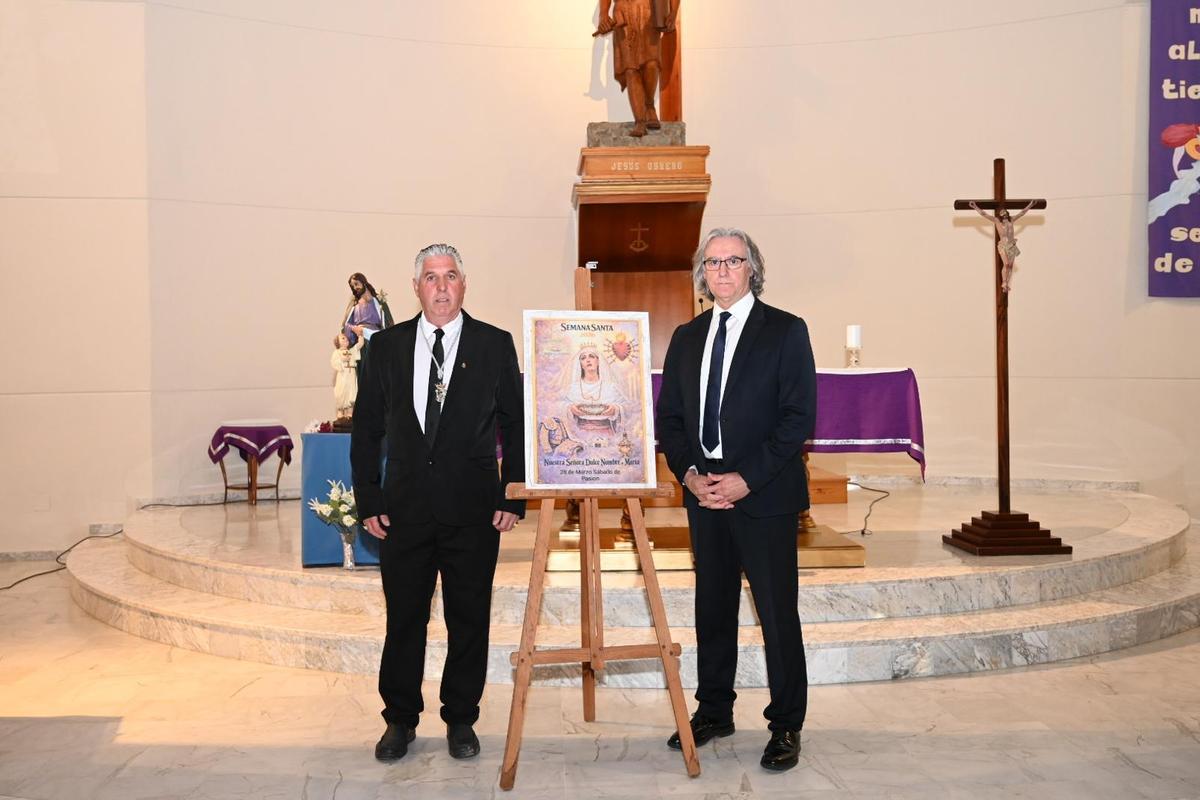 Florencio Rodríguez, hermano mayor de la hermandad de Jesús Obrero, y Miguel Luna, presentador del acto, junto al primer cartel de la Semana Santa de esta cofradía de Badajoz.
