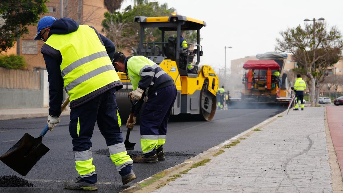 Operarios trabajan en el reasfaltado de la calle.