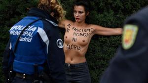 Un agente policial retiene a una activista de Femen, este domingo, en la Plaza de Oriente de Madrid.