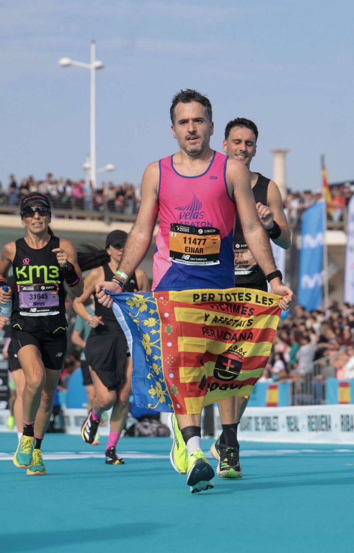 Un deportista entra en la meta con la enseña valenciana.