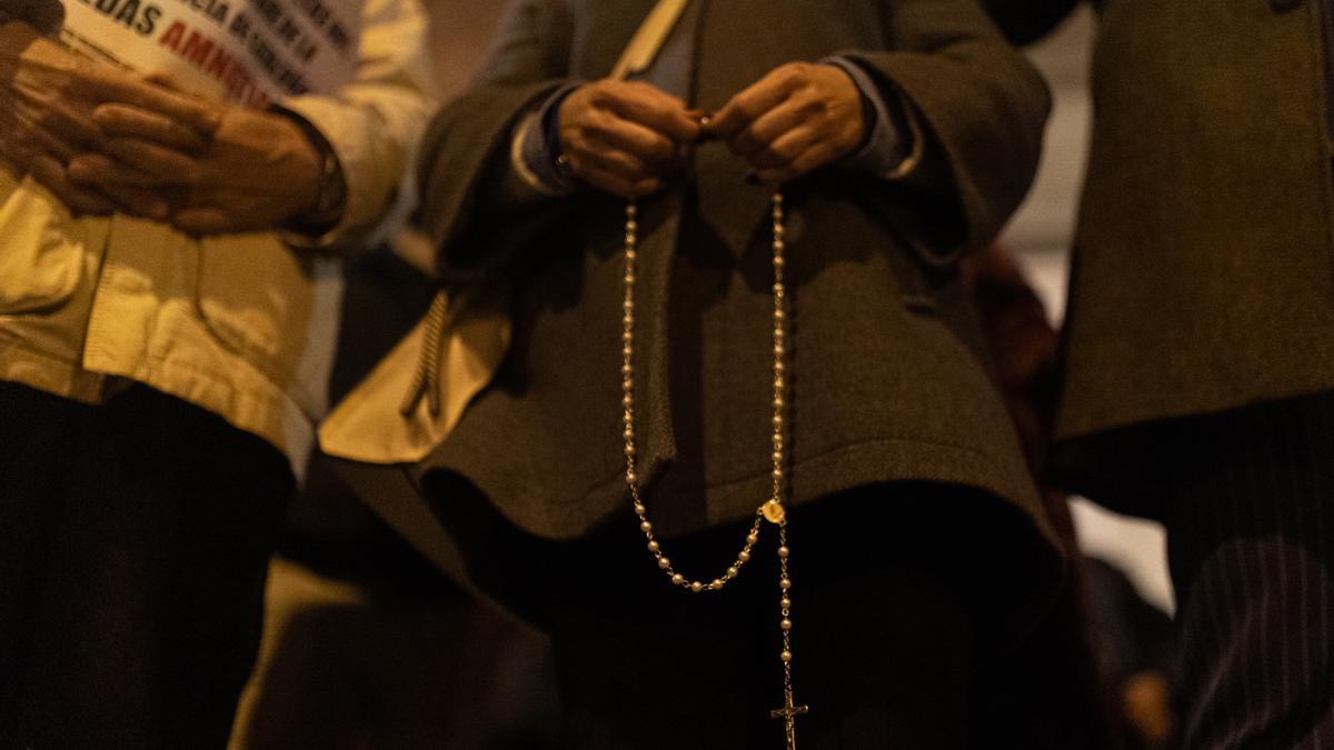 imagen de archivo de una mujer con un rosario durante una manifestación contra la amnistía frente a la sede del PSOE en Ferraz