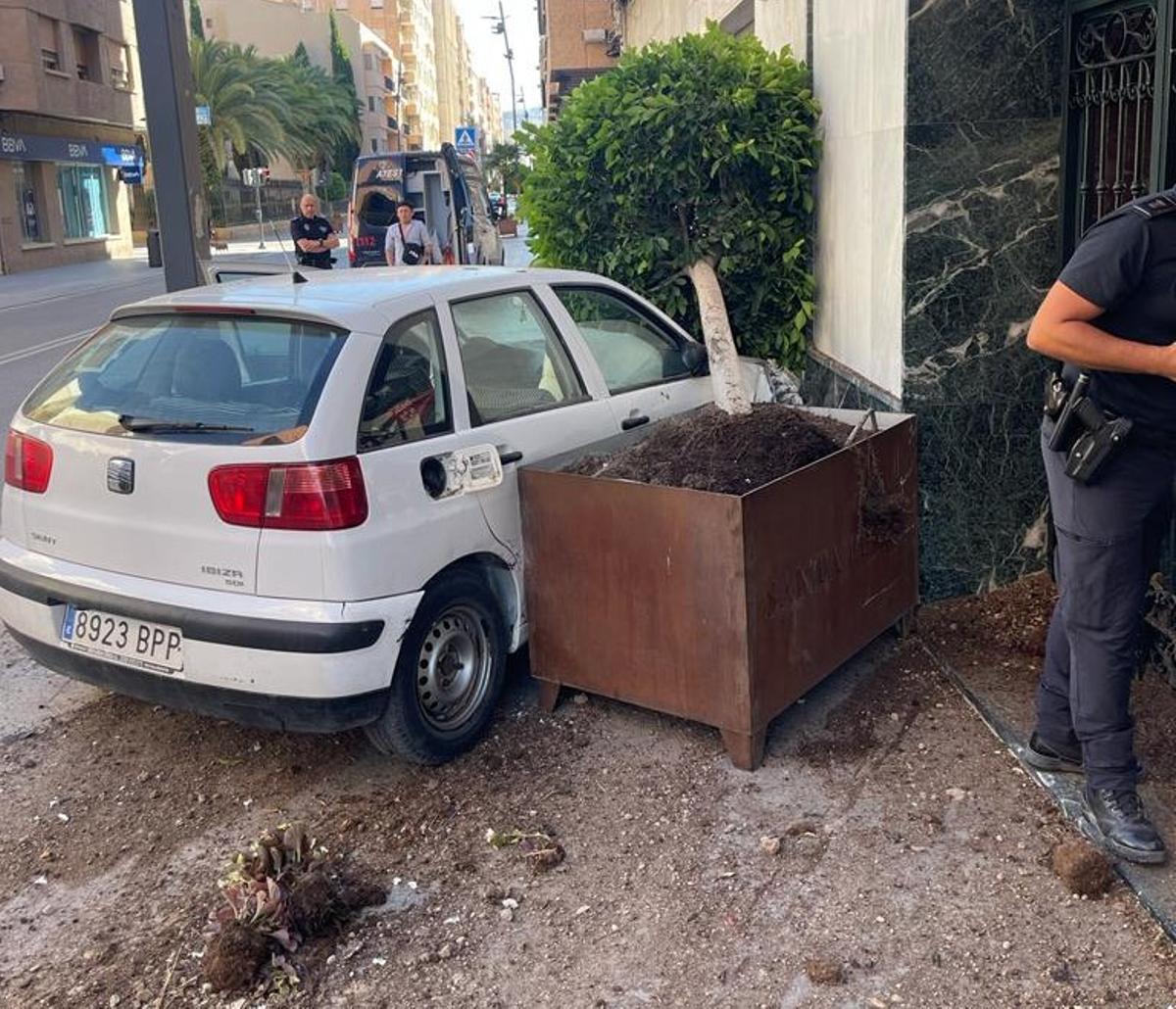 El vehículo junto a la jardinera que arrastraba y estampaba contra el portal de un bloque de viviendas de la avenida de Juan Carlos I.