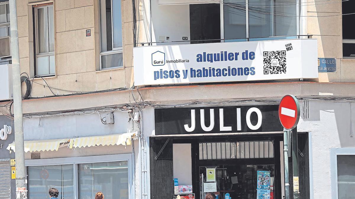 Usuarios caminando por una calle del centro de Murcia donde una inmobiliaria ofrece pisos y habitaciones para alquilar.