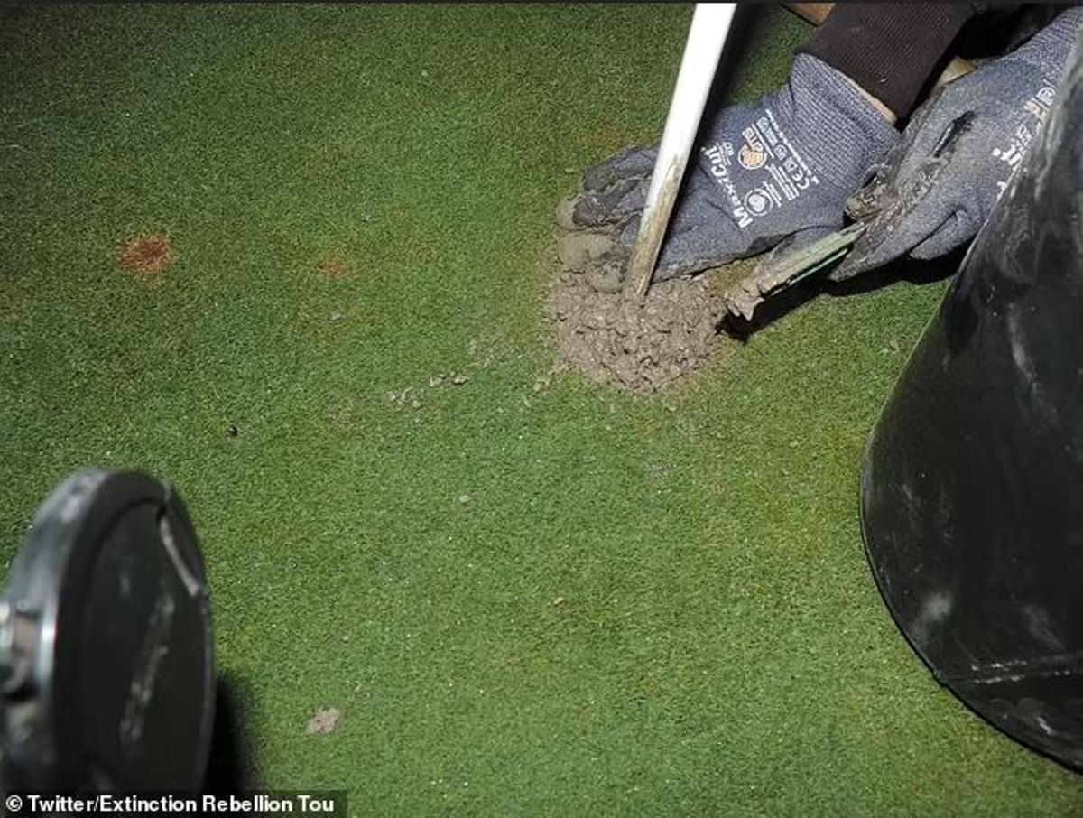 Activista de Extinction Rebellion tapando un hoyo de golf, en una imagen de archivo