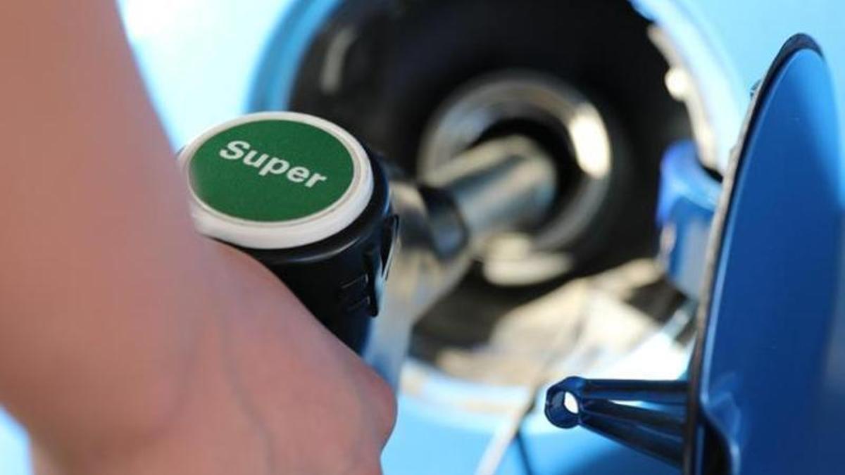Un hombre resposta gasolina en un vehículo.