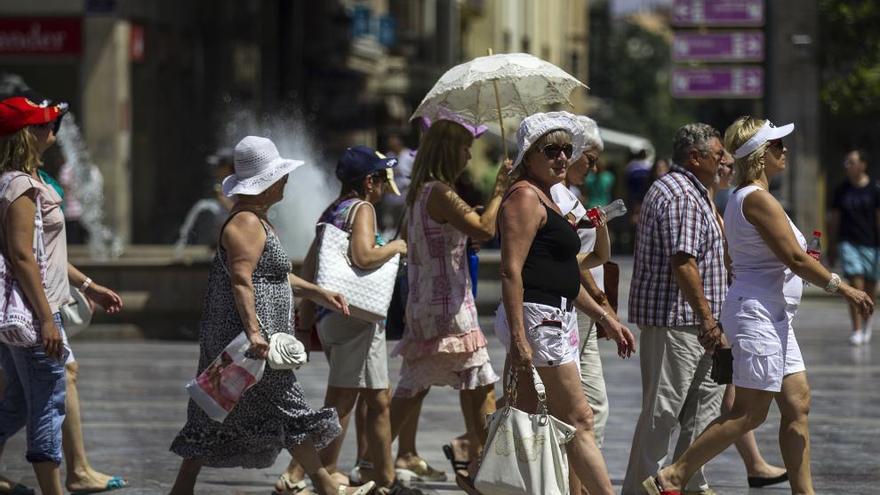 Un grupo de turistas se protegen del intenso sol en Valencia.