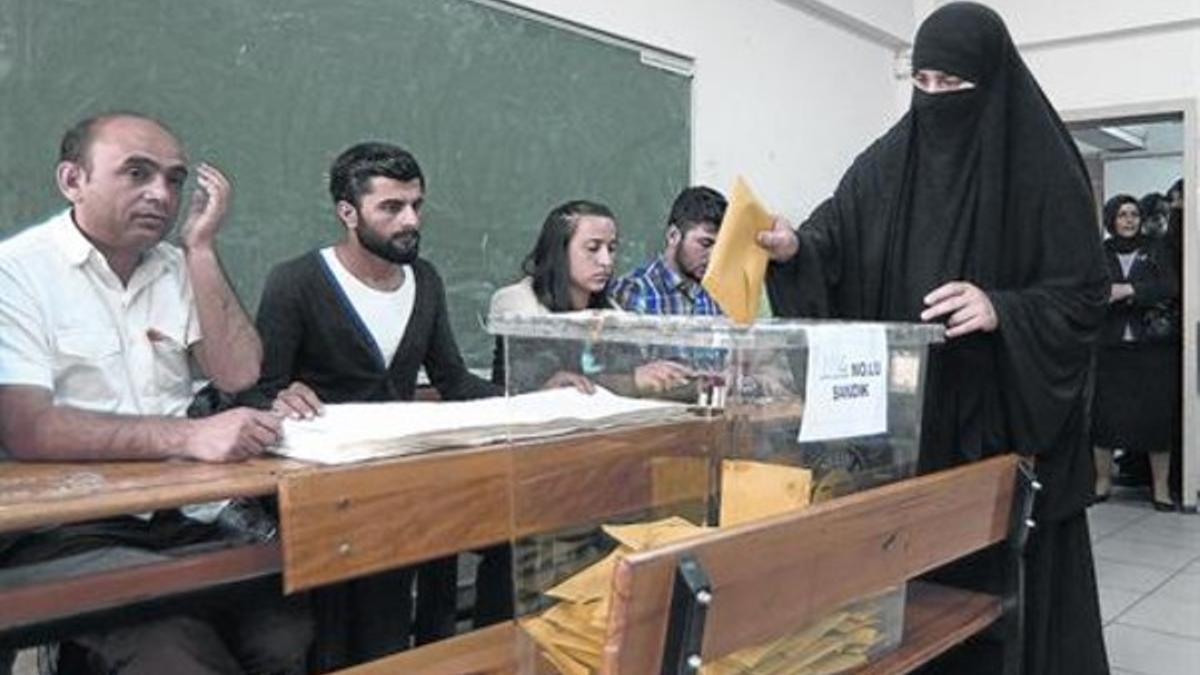 En el colegio electoral 8Una mujer con burka deposita su voto en Estambul, ayer.