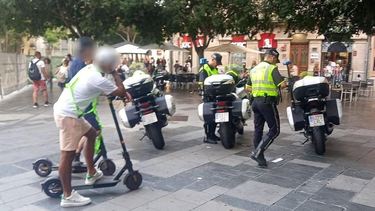 Die Polizei kontrolliert Rollerfahrer auf der Plaça d'Espanya.