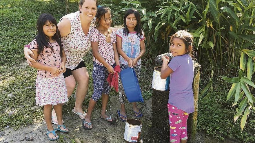 Diana Crespo recoge agua con algunas niñas de la comunidad.