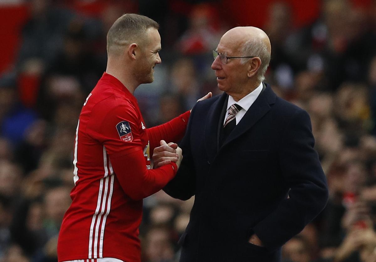 Wayne Rooney del Manchester United con Bobby Charlton antes de un partido