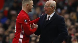 Wayne Rooney del Manchester United con Bobby Charlton antes de un partido