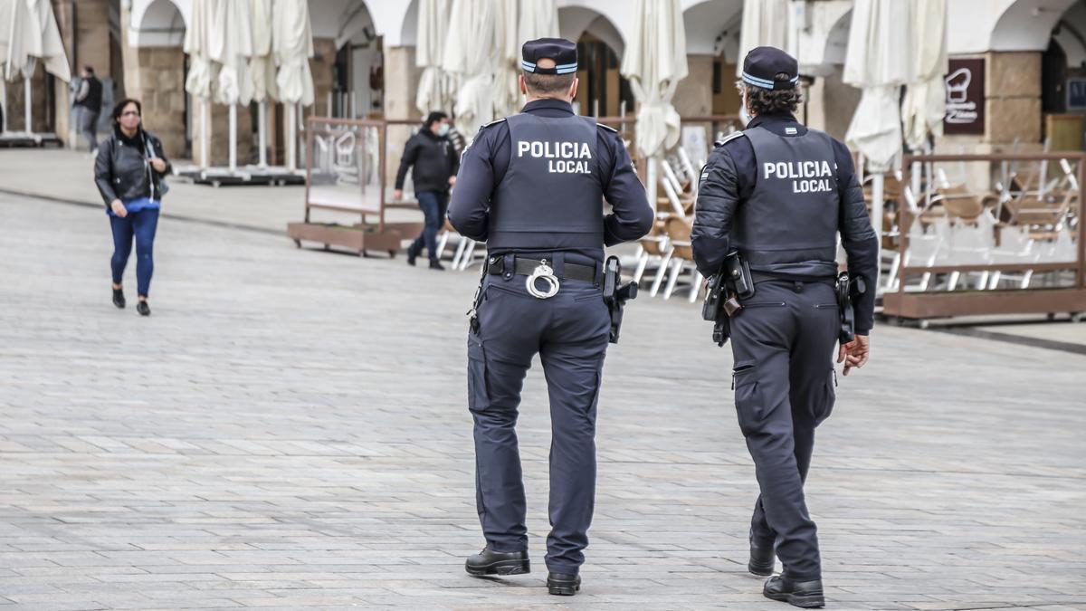 Una pareja de policías patrulla por la plaza Mayor.