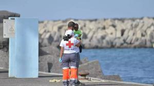 Voluntarios de Cruz Roja sostienen a un menor en Canarias.