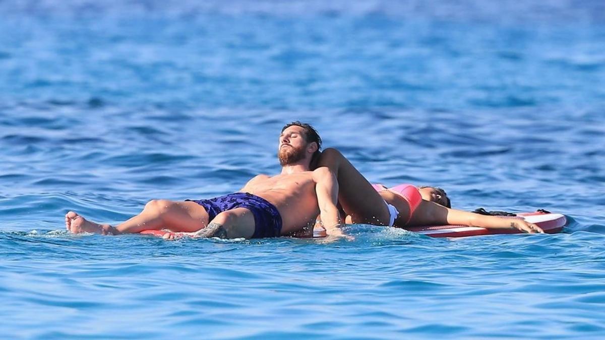 Messi y su mujer Antonella toman el sol sobre una tabla en aguas de Eivissa, este martes.