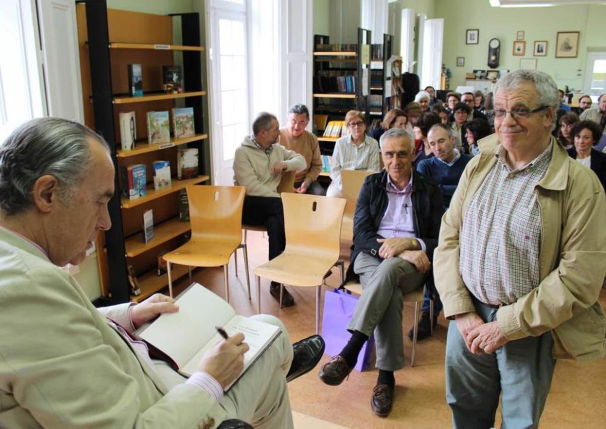 Luis Alberto de Cuenca firmando libros, ayer, en la biblioteca de Castropol.