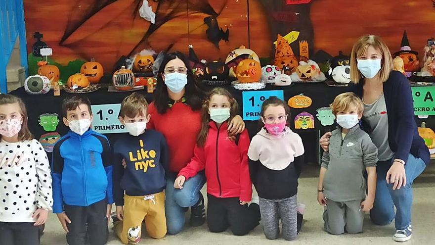 Concursu de calabaces con neños de primeru de Primaria del colexu Eduardo Martínez Torner de Xixón, que posen cola coordinadora del programa billingüe, Noelia Anseán, y la profesora Ana Romero. | D. Á.