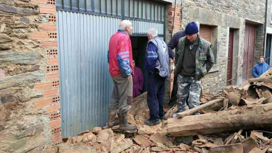 Los vecinos observan los escombros de la casa derrumbada.