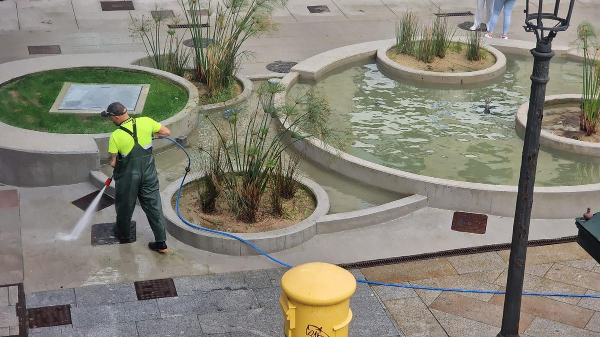 Un trabajador de Urbaser limpiando la calle Arzobispo Lago con agua a presión.