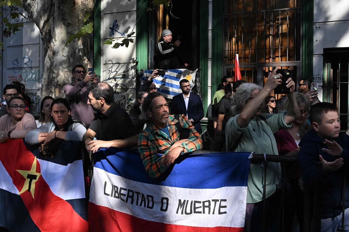 People react while attending the funeral cortege of Uruguays former President Jose Pepe Mujica in downtown Montevideo, on May 14, 2025, a day after his death. Mujica, an ex-guerrilla fighter and hero of the Latin American left, died on May 13, 2025 at the age of 89. The humble leader -- who once spent a dozen years behind bars for revolutionary activity -- lost his battle against cancer after announcing in January the disease had spread and he would stop treatment. (Photo by Eitan ABRAMOVICH / AFP)